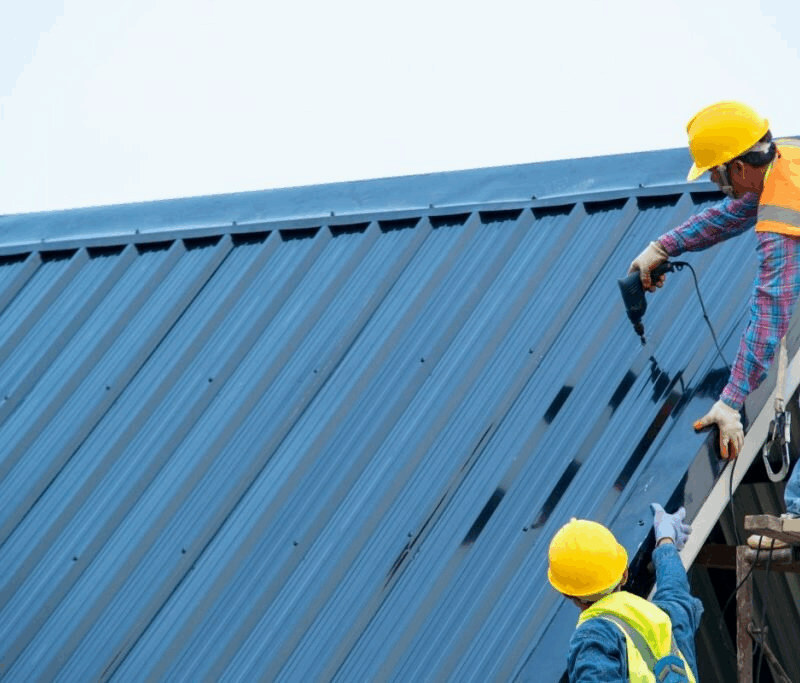 Technician applying metal roof restoration coating